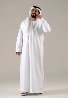 الاهتمام بالمظهر الخارجي والوسامة، بورتريه لرجل عربي خليجي اماراتي يرتدي الكندورة والغترة يرفع يده بايماءات الرد على المكالمات الهاتفية، تلقي أخبار سارة عبر الجوال، مفهوم تبادل المعلومات، حركة يد تدل على الاتصال،الجسم بالطول الكامل، خلفية رمادية