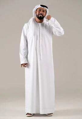 مفهوم تبادل المعلومات، تلقي أخبار سارة عبر الجوال،  حركة يد تدل على الاتصال، الاهتمام بالمظهر الخارجي والوسامة، بورتريه لرجل عربي خليجي اماراتي يرتدي الكندورة والغترة يرفع يده بايماءات الرد على المكالمات الهاتفية، الجسم بالطول الكامل، خلفية رمادية