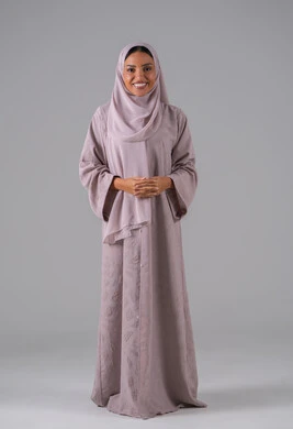 مفهوم النعومة والأنوثة, الاهتمام بالأناقة والمظهر الخارجي، بورتريه لشابة عربيه خليجية سعودية ترتدي الحجاب والعباءة تنظر إلى الكاميرا بإيماءات السرور والسعادة , خلفية رمادية