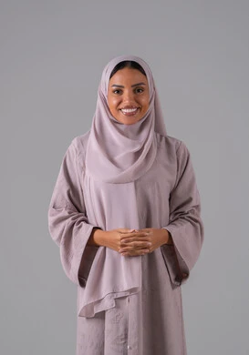 الاهتمام بالأناقة والمظهر الخارجي، مفهوم النعومة والأنوثة, بورتريه لشابة عربيه خليجية سعودية ترتدي الحجاب والعباءة تنظر إلى الكاميرا بإيماءات السرور والسعادة , خلفية رمادية