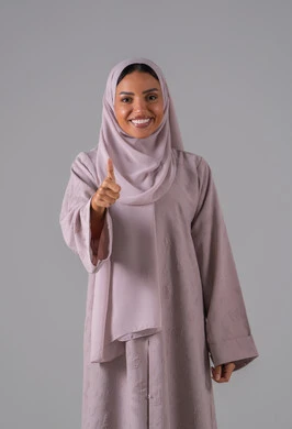 بورتريه لامراه عربيه خليجيه سعودية ترتدي العباءة والحجاب تشير بيدها بإيماءات وتعابير وجه و يدين تدل على الاعجاب، التعبير عن الاتقان، القبول والموافقة والرضا، علامة الجودة والامتياز،خلفية رمادية