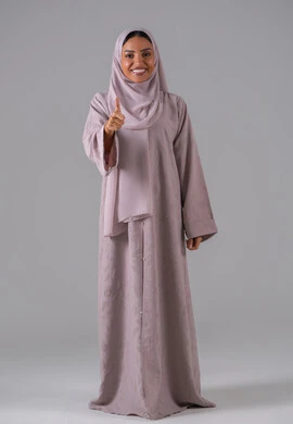 علامة الجودة والامتياز، بورتريه لامراه عربيه خليجيه سعودية ترتدي العباءة والحجاب تشير بيدها بإيماءات وتعابير وجه و يدين تدل على الاعجاب، التعبير عن الاتقان، القبول والموافقة والرضا، خلفية رمادية