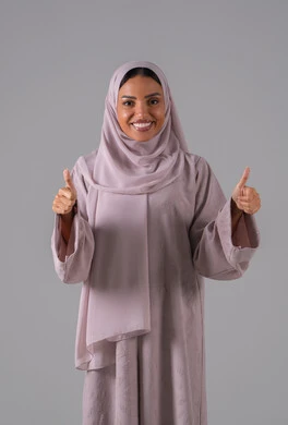 التعبير عن الاتقان، علامة الجودة والامتياز، بورتريه لامراه عربيه خليجيه سعودية ترتدي العباءة والحجاب تشير بيدها بإيماءات وتعابير وجه و يدين تدل على الاعجاب، القبول والموافقة والرضا، خلفية رمادية
