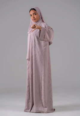 الإنزعاج من شيء ما ، بورتريه لامراه عربيه خليجيه سعودية ترتدي العباءه والحجاب تشير بأصبع الإبهام لأسفل, ايماءات عدم الموافقه وعدم الإعجاب والرفض ، خلفية رمادية