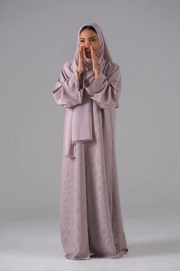 النداء والكلام بصوت عالي، بورتريه لامرأة عربية خليجية سعودية ترتدي العباءة والحجاب تضع يدها على فمها بإيماءات تدل على المناداة، مفهوم الدردشات والمحادثات، خلفية رمادية