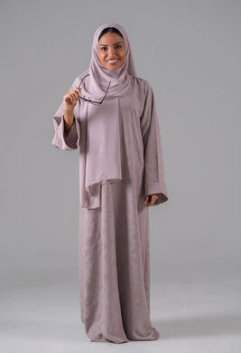 بورتريه لامرأة عربية خليجية سعودية ترتدي العباءه والحجاب والنظارات الطبيه بايماءات السرور والسعادة ، مفهوم ضعف البصر، الاناقة والاهتمام بالمظهر الخارجي،خلفية رماديه