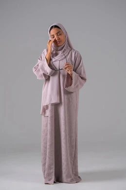 مفهوم ضعف البصر، الاناقة والاهتمام بالمظهر الخارجي، بورتريه لامرأة عربية خليجية سعودية ترتدي العباءه والحجاب والنظارات الطبيه بايماءات التفاعل والاندماج، خلفية رماديه