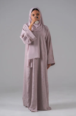 مفهوم الاهتمام بالمظهر الخارجي، الاستمتاع في تناول المشروبات الساخنه ، النظر بإيماءات الاندماج ، منتجات محلية وطنية سعودية، بورتريه لامراة عربيه خليجية سعودية ترتدي العباءة والحجاب تحمل بيدها كوب من القهوة، خلفية رمادية