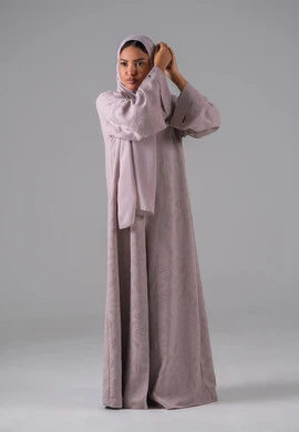 الاهتمام بالأناقة والمظهر الخارجي, مفهوم الأنوثة والنعومة, أزياء محجبات عصرية أنيقة, بورترية لشابة عربية خليجية سعودية ترتدي العباءة وتعدل من وضعية الحجاب تقف بتعابير الثقة والاعتزاز بالنفس ، خلفية رمادية