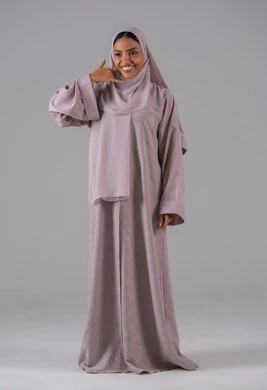 Receiving good news via mobile, the concept of information exchange, a hand gesture indicating communication, concern for appearance and attractiveness, a portrait of an Arab Gulf Saudi woman wearing an abaya and hijab raising her hand in gestures to answer phone calls, full-body, gray background.