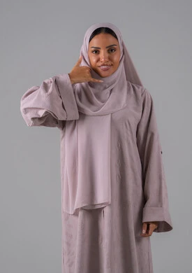 مفهوم تبادل المعلومات، تلقي أخبار سارة عبر الجوال،حركة يد تدل على الاتصال، الاهتمام بالمظهر الخارجي والوسامة، بورتريه لامراه عربيه خليجيه سعودية ترتدي العباءة والحجاب ترفع يدها بايماءات الرد على المكالمات الهاتفية، الجسم بالطول الكامل، خلفية رمادية