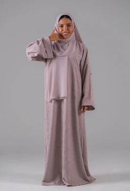 تلقي أخبار سارة عبر الجوال، مفهوم تبادل المعلومات، حركة يد تدل على الاتصال، الاهتمام بالمظهر الخارجي والوسامة، بورتريه لامراه عربيه خليجيه سعودية ترتدي العباءة والحجاب ترفع يدها بايماءات الرد على المكالمات الهاتفية، الجسم بالطول الكامل، خلفية رمادية