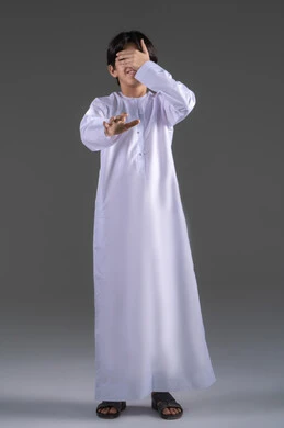 الم في العيون والرأس ، عدم وضوح الرؤية بشكل جيد، إغلاق العيون باستخدم اليدين،   التركيز على شيء ما، بورتريه لولدعربي خليجي سعودي يرتدي الثوب التقليدي  يضع يده على عينيه بشكل  بإيماءات عدم العثور على شيء، الجسم بالطول الكامل، خلفية رمادي