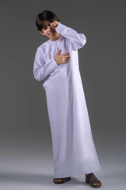 التباكي ومشاعر الحزن، إغماض العينين وعدم الرغبة بالرؤية، الشعور بالخجل والإحراج، التعرض لصدمة وعدم التصديق، بورتريه لولد عربي خليجي سعودي يرتدي الثوب التقليدي يغطي وجهه بيديه، الجسم بالطول الكامل، المشاعر والاحاسيس المرهفة، خلفية رمادي