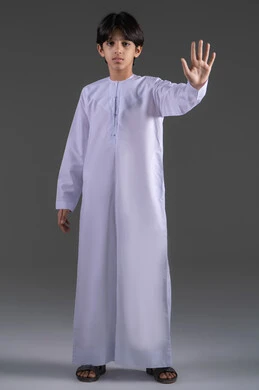 تعابير الحزم والجدية, طلب التوقف وعدم الاقتراب, مفهوم الرفض والامتناع والانزعاج, بورتريه لولد عربي خليجي سعودي يرتدي الثوب الابيض التقليدي يمد يده نحو الأمام مع رفع الكف بإيماءات النهي عن فعل امر ما, صورة الجسم بالطول الكامل، خلفية رمادي