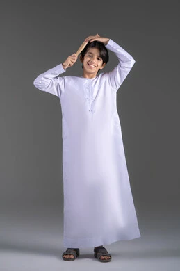 تمشيط وترتيب الشعر، مفهوم العناية والاهتمام بالجمال والأناقة والمظهر الخارجي، بورتريه لولد عربي خليجي اماراتي يقوم بتصفيف شعره باستخدام فرشاة الشعر ( المشط ) بتعابير وإيماءات تدل على السعادة والسرور، خلفية سوداء