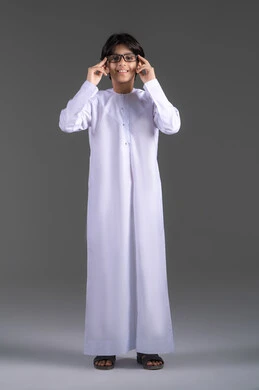 Wearing glasses to improve vision, attention to appearance, a portrait of an Emirati Gulf Arab boy wearing a kandura, wearing prescription glasses, looking at the camera with gestures of joy and happiness, the concept of poor eyesight, full-body, gray background. Wearing glasses to improve vision, attention to appearance, a portrait of an Emirati Gulf Arab boy wearing a kandura, wearing prescription glasses, looking at the camera with gestures of joy and happiness, the concept of poor eyesight, full-body, gray background.