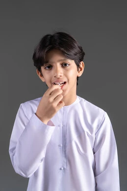 The concept of oral health care, ensuring the cleanliness of teeth after eating, maintaining a bright white smile, a portrait of an Emirati Gulf Arab boy wearing a kandura and cleaning his teeth with dental floss, attention to elegance and appearance, gray background. The concept of oral health care, ensuring the cleanliness of teeth after eating, maintaining a bright white smile, a portrait of an Emirati Gulf Arab boy wearing a kandura and cleaning his teeth with dental floss, attention to elegance and appearance, gray background.