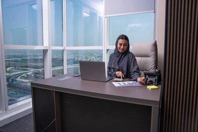 قسم التحليلات والإحصائيات البيانية،امراه عربية خليجية اماراتية ترتدي العباءة و الحجاب تعمل على إدارة الحسابات، إستخدام جهاز الحاسوب المحمول، مهن ووظائف مكتبية، إستخدام الآلة الحاسبة لإجراء العمليات الحسابية، البورصة والإستثمار المالي