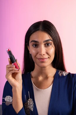 التسويق لمنتجات التجميل، بورترية مقرب لمرأة عربية خليجية سعودية ترتدي الزي الكاجوال  تحمل إحدى أدوات التجميل (قلم أحمر الشفاة)، مرأة خبيرة بمستحضرات التجميل، متجر بيع مستحضرات التجميل عبر الإنترنت، مفهوم الإهتمام بالجمال والبشرة، ادوات مكياج تتوريال، صالون تجميلي نسائي، خلفية ملونه