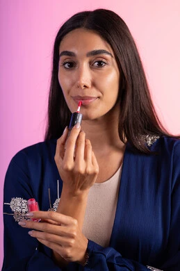 صالون تجميلي للنساء، التسويق لمنتجات التجميل، بورترية مقرب لمرأة عربية خليجية سعودية ترتدي الزي الكاجوال  تحمل إحدى أدوات التجميل (قلم أحمر الشفاة)، مرأة خبيرة بمستحضرات التجميل، متجر بيع مستحضرات التجميل عبر الإنترنت، مفهوم الإهتمام بالجمال والبشرة، ادوات مكياج تتوريال، خلفية ملونه