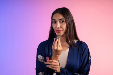 صالون للعناية بالبشرة والشعر للسيدات، التسويق لمنتجات التجميل، بورترية مقرب لمرأة عربية خليجية سعودية ترتدي الزي الكاجوال  تحمل إحدى أدوات التجميل (قلم أحمر الشفاة)، مرأة خبيرة بمستحضرات التجميل، متجر بيع مستحضرات التجميل عبر الإنترنت، مفهوم الإهتمام بالجمال والبشرة، ادوات مكياج تتوريال، خلفية ملونه