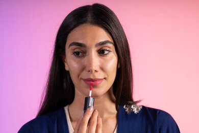 صالون نسائي للعناية بالجمال، التسويق لمنتجات التجميل، بورترية مقرب لمرأة عربية خليجية سعودية ترتدي الزي الكاجوال  تحمل إحدى أدوات التجميل (قلم أحمر الشفاة)، مرأة خبيرة بمستحضرات التجميل، متجر بيع مستحضرات التجميل عبر الإنترنت، مفهوم الإهتمام بالجمال والبشرة، ادوات مكياج تتوريال، خلفية ملونه