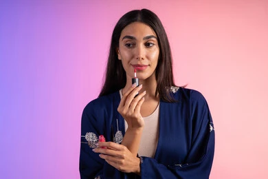 مركز تجميل للسيدات، التسويق لمنتجات التجميل، بورترية مقرب لمرأة عربية خليجية سعودية ترتدي الزي الكاجوال  تحمل إحدى أدوات التجميل (قلم أحمر الشفاة)، مرأة خبيرة بمستحضرات التجميل، متجر بيع مستحضرات التجميل عبر الإنترنت، مفهوم الإهتمام بالجمال والبشرة، ادوات مكياج تتوريال، خلفية ملونه