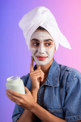 استخدام منتج تجميلي، مفهوم العناية بنضارة وتحسين البشرة، بورتريه مقرب لامرأة عربية خليجية سعودية ترتدي منشفة الرأس و الزي الكاجوال تمسك بيدها علبة جل الترطيب،خلفية ملونه