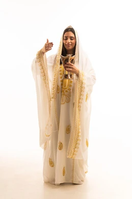 استخدام خشب العود في المناسبات والأعياد، بورتريه لإمرأه عربيه سعوديه خليجيه ترتدي العباءه الزخرفة تحمل حامل البخور ( المبخرة ) ، التطيب بالبخور والعود , العادات والتقاليد السعودية، الجسم بالطول الكامل، خلفية بيضاء