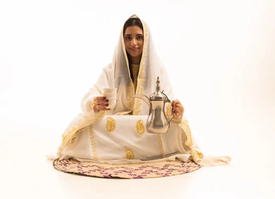 الولاء والانتماء للوطن، ذكرى تأسيس الدولة السعودية الاولى 22 فبراير، مفهوم الكرم وحسن الاستقبال، يوم بدينا 1727 م، بورتريه لامراة عربية خليجية سعودية محجبة ترتدي الشيلة والسدرة تجلس على حصيرة من القش تقوم بصب القهوة من الدلة النحاسية، خلفية بيضاء