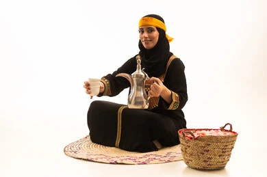حب الوطن والانتماء اليه، ذكرى تأسيس الدولة السعودية الاولى 22 فبراير، مفهوم الكرم وحسن الاستقبال، يوم بدينا 1727 م، بورتريه لامراة عربية خليجية سعودية محجبة ترتدي الشيلة والسدرة تجلس على حصيرة من القش تقوم بصب القهوة من الدلة النحاسية، خلفية بيضاء
