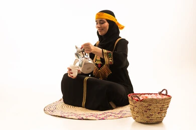 حب الوطن والانتماء اليه، ذكرى تأسيس الدولة السعودية الاولى 22 فبراير، مفهوم الكرم وحسن الاستقبال، يوم بدينا 1727 م، بورتريه لامراة عربية خليجية سعودية محجبة ترتدي الشيلة والسدرة تجلس على حصيرة من القش تقوم بصب القهوة من الدلة النحاسية، خلفية بيضاء