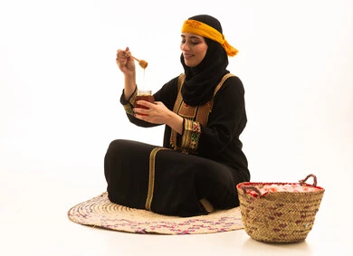إرتداء أزياء المنطقة الجنوبية، يوم بدينا1727م، منتجات غذائية صحية ومفيدة صنعت في السعودية، بورتريه لفتاة عربية خليجية سعودية ترتدي الشيلة والسدره تحمل بيدها ملعقة مغمورة من عسل النحل الطبيعي في وعاء زجاجي، ذكرى تاسيس الدولة السعودية22 فبراير، تعابير الفخر والسرور، خلفية بيج