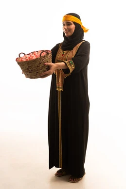 ارتداء أزياء المنطقة الجنوبية، الزهور والورود العطرية، يوم بدينا1727م، بورتريه لامراة عربية خليجية سعودية ترتدي الشيلة والسدره تحمل بيدها سلة قش ممتلئة بالورد الجوري الطبيعي، ذكرى تاسيس الدولة السعودية 22فبراير، تعابير الفخر والاعتزاز، الجسم الكامل بالطول، خلفية بيضاء