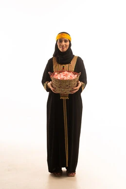 الزهور والورود العطرية، يوم بدينا1727م، بورتريه لامراة عربية خليجية سعودية ترتدي الشيلة والسدره تحمل بيدها سلة قش ممتلئة بالورد الجوري الطبيعي، ارتداء أزياء المنطقة الجنوبية، ذكرى تاسيس الدولة السعودية 22فبراير، تعابير الفخر والاعتزاز، الجسم الكامل بالطول، خلفية بيضاء