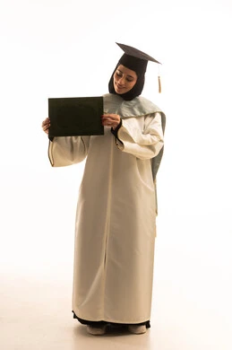 Celebrating success and the end of the academic year, academic education in Saudi Arabia, a portrait of a smiling Arab Saudi Gulf student wearing an abaya and graduation cap holding her diploma in her hands, the concept of excellence and graduating from university, full-body image, white background.
