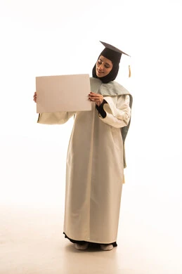 لوحات توضيحية ووسائل تعليمية، الاحتفال بإنهاء الدراسة الجامعية، بورتريه لخريجة عربية سعودية خليجية محجبة ترتدي العباءة البيضاء وقبعة التخرج تمسك بيدها موك اب مستطيل أبيض و تنظر اليه بايماءات السعادة و السرور، الجسم بالطول الكامل، خلفية بيضاء