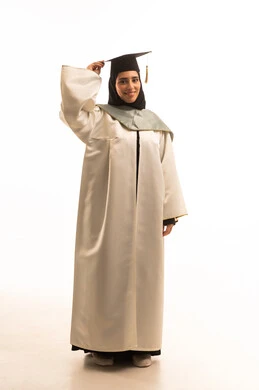 Gestures of happiness at reaching the dream of success, a portrait of a smiling Saudi Gulf Arab graduate wearing a hijab and graduation gown, holding the cap with expressions of joy and excitement, celebrating the completion of university studies, graduation party, full-body shot, white background.