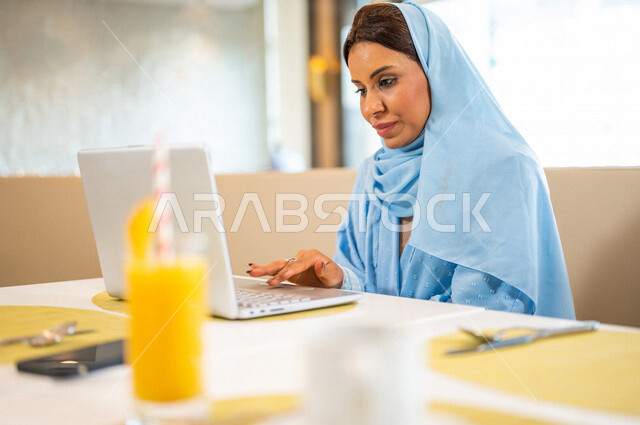إمرأه عربيه سعوديه خليجيه تجلس في المقهى, تنظيم وادارة جدول مهام العمل,اجتماع عمل, العمل عن بعد, مشروع عمل جديد, بناء علاقات وصداقات عبر الانترنت, انجاز المهام اليوميه, الاستمتاع باجواء هادئه خارج المنزل