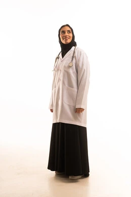 تقديم المساعده الطبية للمرضى، مهن ووظائف نسائية, العمل في المراكز والمستشفيات, بورتريه لطبيبة عربية خليجية سعودية ترتدي المعطف الطبي وسماعة الفحص تقف باستقامة تنظر إلى شيء ما بايماءات الثقة بالنفس, الجسم بالطول الكامل، خلفية بيضاء