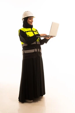 انجاز مهام العمل عبر الحاسوب المحمول, ادارة المشاريع الهندسية, بورتريه لمهندسة عربية خليجية سعودية ترتدي سترة وخوذة الحماية تحمل الابتوب, العمل في القطاع الهندسي, شابة سعودية تقوم بدراسة أساسيات المشروع, صورة لكامل الجسم، خلفية بيضاء