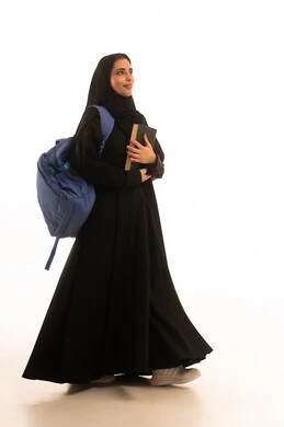 جامعات ومدارس تعليمية، الاستعداد للعام الدراسي الجامعي الجديد, بورتريه لطالبة جامعية عربية خليجية سعودية تحمل الحقيبة الجامعية تمسك بيدها كتاب, شابة سعودية مجتهدة متشوقة للذهاب الى الجامعه, الجسم بالطول الكامل، خلفية بيضاء