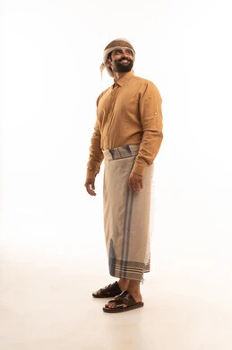 النظر الى مكان ما بايماءات الثقة بالنفس، الاهتمام بالمظهر الخارجي، مفهوم الأناقة والرجولة, بورتريه لرجل عربي يمني يرتدي القميص والازار مع العمامة يقف باستقامة واعتدال, الجسم بالطول الكامل، خلفية بيضاء