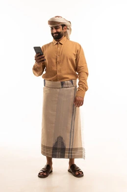 Chatting with family and friends via mobile phone, the concept of modern technologies and devices, a portrait of a Yemeni Arab man wearing a shirt and a waist wrap with a turban holding a mobile phone in his hand, full-body image, white background.