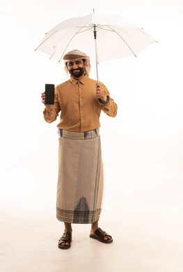 عرض شاشة سوداء فارغة عبر الهاتف المحمول، بورتريه لرجل عربي يمني يرتدي القميص والازار مع العمامة يحمل بيده مظلة، الحماية من الأمطار في الشتاء، الجسم بالطول الكامل، خلفية بيضاء