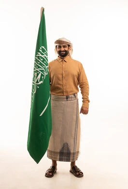 Gestures of pride and joy in belonging to the homeland, commemorating Saudi National Day on September 23, Saudi Flag Day on March 11, a portrait of a Yemeni Arab man wearing a thobe and izar with a turban holding the Kingdom's flag in his hand, the year 1727 AD, full-body, white background.