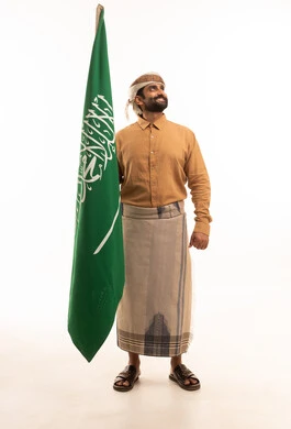 يوم العلم السعودي 11 مارس، إحياء ذكرى اليوم الوطني السعودي 23 سبتمبر, إيماءات الفخر و السرور بالانتماء للوطن, بورتريه لرجل عربي يمني يرتدي القميص والازار مع العمامة يحمل بيده علم المملكة، يوم بدينا 1727 م، الجسم بالطول الكامل، خلفية بيضاء