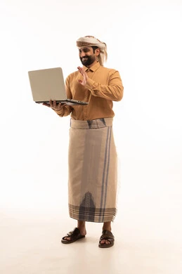 Making a video call, raising the hand with expressions of joy, a portrait of a Yemeni Arab man wearing a shirt and a sarong with a turban working on a laptop, remote work and completing the required tasks, full body, white background.