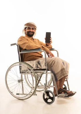 عرض شاشة سوداء فارغه عبر الجوال، تعابير السعادة و السرور، استخدام التكنولوجيا و التقنيات الحديثة,  بورتريه لرجل عربي يمني يرتدي القميص والازار مع العمامة يجلس على كرسي متحرك يحمل بيده موبايل، خلفية بيضاء